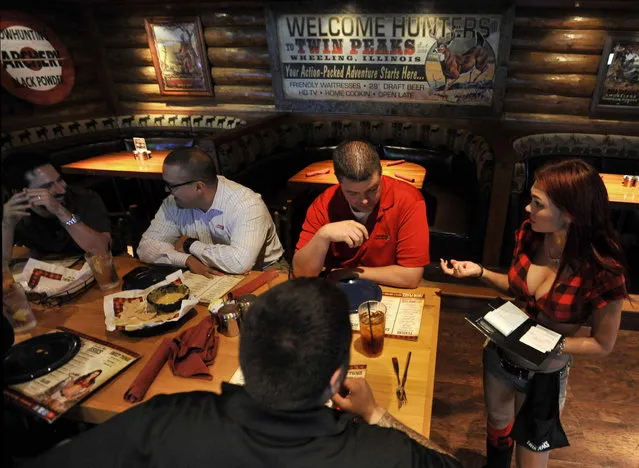 A waitress serves diners at Twin Peaks restaurant in Wheeling, Il.  on Thursday, October 3, 2013. Twin Peaks is one of the new wave of  that have been growing rapidly the last few years, in part at the expense of Hooters, which is still the biggest in the category, but has been struggling somewhat. Twin Peaks and rival Tilted Kilt dress their waitresses in even skimpier outfits than Hooters – short shorts, bare midriffs and big emphasis on cleavage. A restaurant-industry veteran recently bought the rights to open franchised Twin Peaks locations in the Milwaukee area and is currently scouting local real estate. (Photo by Paul Beaty/Journal Sentinel)