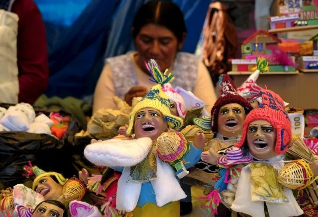 An Aymara woman offers statues of the Ekeko, god of fortune, to sell during the “Alasitas” fair in La Paz, Bolivia, January 19, 2016. (Photo by David Mercado/Reuters)