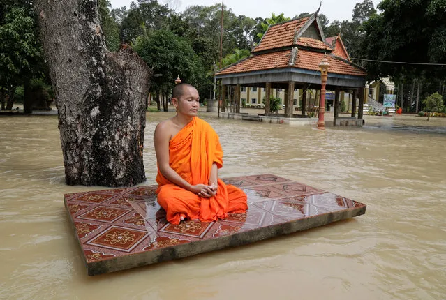 A Cambodian Buddhist monk meditates at his flooded pagoda on the outskirts of Phnom Penh, Cambodia, 21 July 2018. According to local media reported thousand hectares of crops and 1,786 houses have been flooded in some Cambodian western provinces after a heavy rainfall. (Photo by Mak Remissa/EPA/EFE)