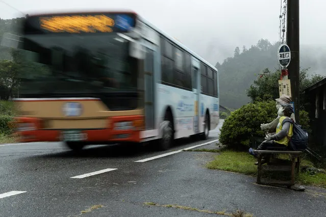 Handmade human-sized scarecrows sit on a bench while an empty bus drives past in the village of “Kakasi No Sato” on September 20, 2023 in Yasutomi, Japan. (Photo by Buddhika Weerasinghe/Getty Images)