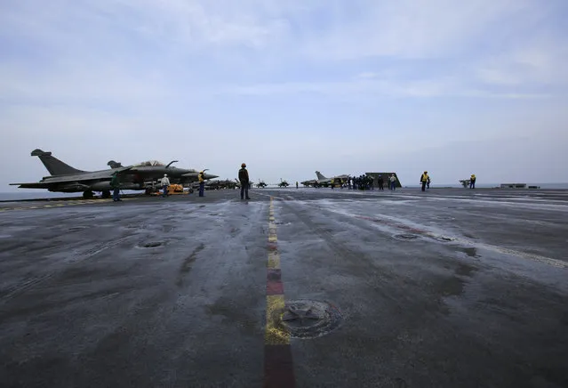 French sailors work on the flight deck of the French Navy aircraft carrier Charles de Gaulle Wednesday, March 18, 2015, in the Persian Gulf. (Photo by Hasan Jamali/AP Photo)