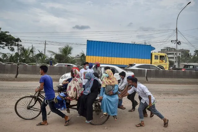Migrants and other people board a cycle rickshaw cart as they leave for their native places after Bangladesh's authorities ordered a new lockdown to contain the spread of Covid-19 coronavirus in Dhaka on June 28, 2021. (Photo by Munir Uz Zaman/AFP Photo)