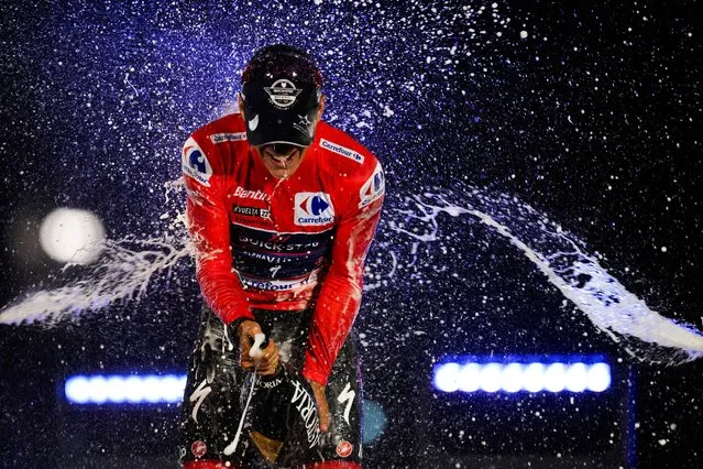 Belgian Remco Evenepoel of Quick-Step Alpha Vinyl celebrates by spraying cava on the podium after winning La Vuelta cycling race in Madrid, Spain, Sunday, September 11, 2022. (Photo by Manu Fernandez/AP Photo)