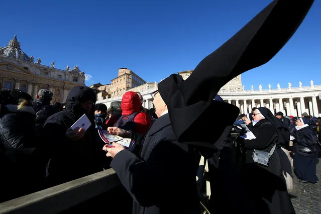 A nun distributes books titled “Icons of Mercy” donated by Pope Francis to the faithful on Epiphany day in Saint Peter's Square at the Vatican January 6, 2017. (Photo by Stefano Rellandini/Reuters)