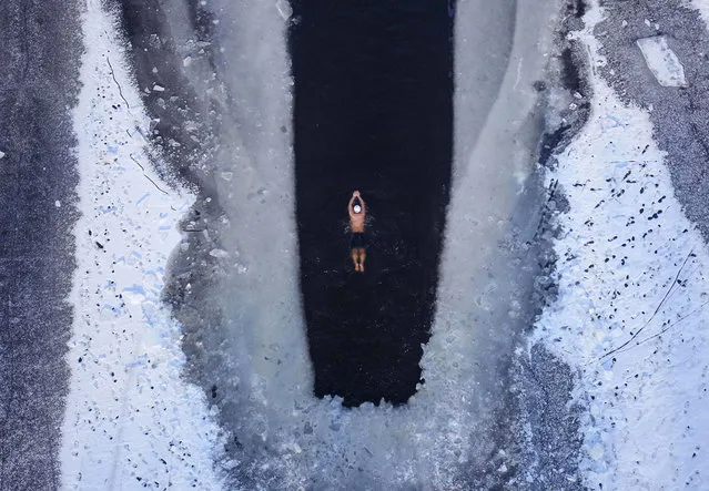 This photo taken on December 10, 2018 shows an aerial view of a man swimming in a partly frozen lake, in a temperature of minus 20 degrees Celsius in Shenyang in China's northeastern Liaoning province. (Photo by AFP Photo/Stringer)