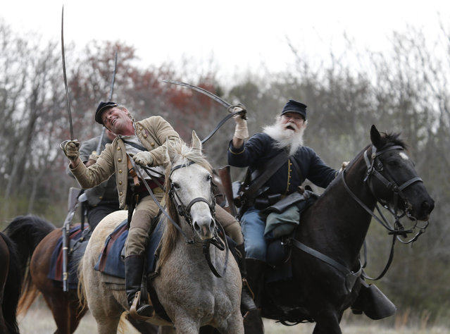Confederate and Union forces clash during a re-enactment of the Battle of Appomattox Station, Wednesday, April 8, 2015, as part of the 150th anniversary of the surrender of the Army of Northern Virginia to Union forces at Appomattox Court House, in Appomattox, Va. (Photo by Steve Helber/AP Photo)