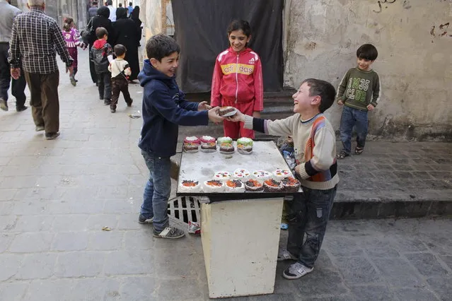 A child sells cake in Old Aleppo, November 3, 2013. (Photo by Molhem Barakat/Reuters)