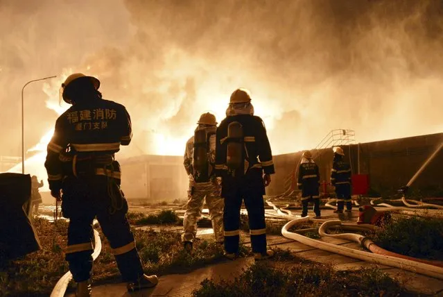 Firefighters look on as they try to extinguish a fire at a petrochemical plant in Zhangzhou, Fujian province April 7, 2015. At least six people were injured after an explosion hit part of an oil storage facility on Monday at Dragon Aromatics, an independent petrochemical producer in eastern China, Xinhua reported. (Photo by Reuters/Stringer)