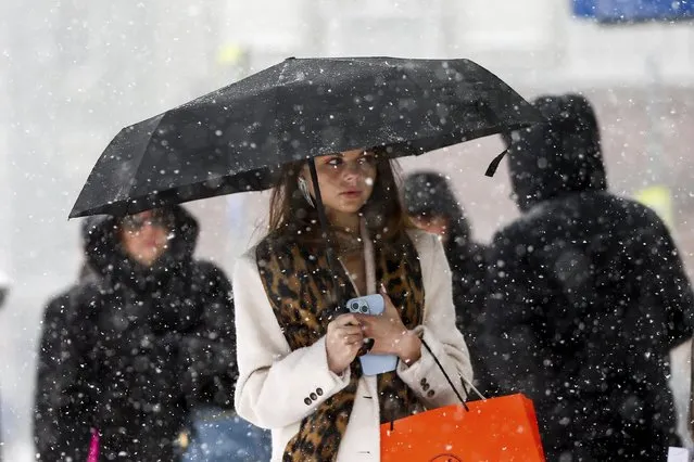 A woman walks down a street during heavy snowfall in Moscow, Russia, Sunday, December 3, 2023. A record snowfall has hit Russia's capital bringing an additional 10 cm to already high levels of snow and causing disruption at the capital's airports and on roads. (Photo by Sergei Vedyashkin/Moscow News Agency via AP Photo)