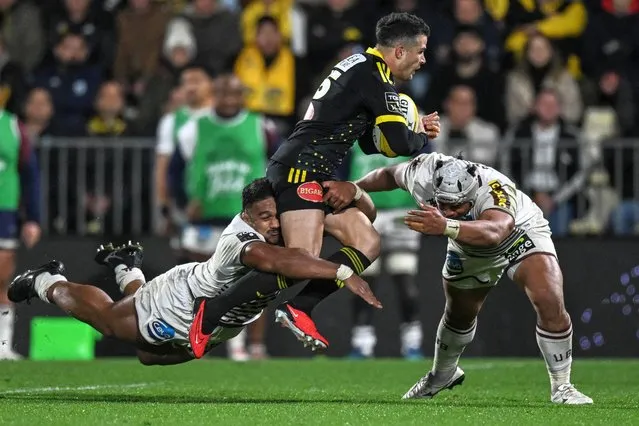 La Rochelle's French full-back Brice Dulin is tackled by Bordeaux-Begles' French centre Yoram Moefana (L) and Bordeaux-Begles' Japanese flanker Tevita Tatafu during the French Top14 rugby union match between Stade Rochelais (La Rochelle) and Union Bordeaux-Begles (UBB) at The Marcel-Deflandre Stadium in La Rochelle, western France on november 19, 2023.  (Photo by Xavier Leoty/AFP Photo)