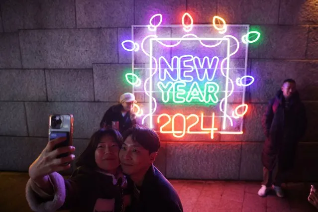 A couple takes a selfie in front of a 2024 luminous sign during New Year’s Eve in Seoul, South Korea on December 31, 2023. (Photo by Kim Hong-Ji/Reuters)