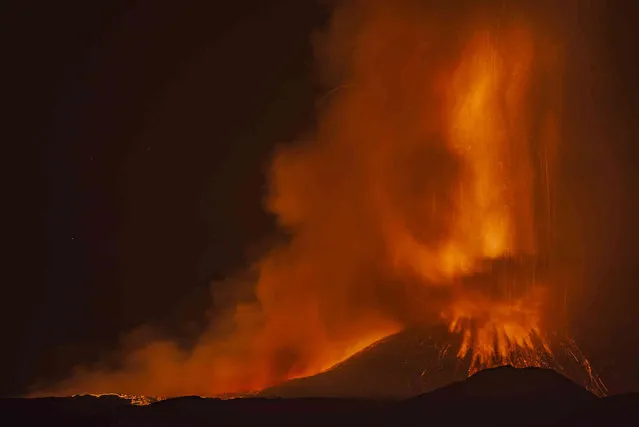 Lava erupts from a crater of Mt. Etna, Europe's largest active volcano, near Catania, in southern Italian island of Sicily, late Saturday, July 31, 2021. While Catania is suffering because of wildfires that reached the outskirts of the city – due to extremely high temperature and, sometimes, arson – the volcano continues its spectacular activities. (Photo by Salvatore Allegra/AP Photo)
