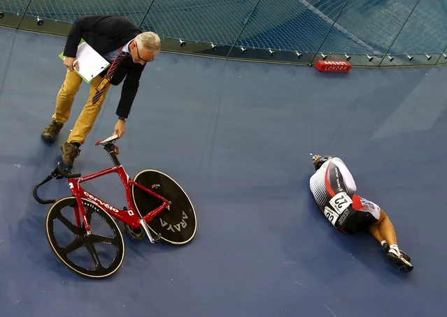 UCI World Track Cycling Championships, London, Britain on March 3, 2016: A track commissaire picks up the bicycle of Eiya Hashimoto of Japan after he crashed during the men's point race. (Photo by Andrew Winning/Reuters)