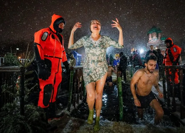 Russian Orthodox believers take a dip in the ice cold water of a pond during the celebrations of the Orthodox Epiphany holiday, in Moscow, Russia on January 18, 2024. People believe that dipping into blessed waters during the holiday of Epiphany strengthens their spirit and body. (Photo by Yuri Kochetkov/EPA/EFE)
