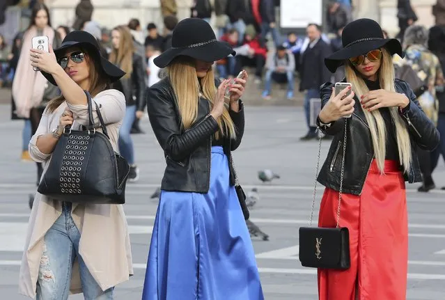 Women use their mobile phones in Duomo Square in downtown Milan, Italy, February 25, 2016. (Photo by Stefano Rellandini/Reuters)