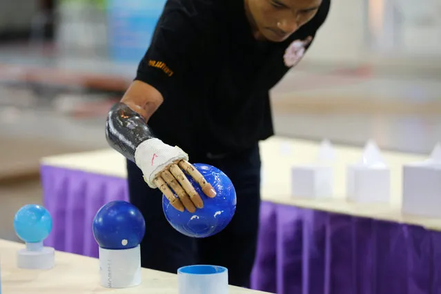 Pongchai Nakken, 31, holds a ball with his robotic hand during a robotics fair aimed at helping people with disabilities, in Bangkok, Thailand, January 30, 2017. (Photo by Chaiwat Subprasom/Reuters)