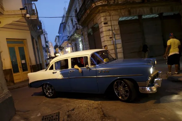 People ride in a vintage car turned taxi in Havana, March 16, 2016. (Photo by Ueslei Marcelino/Reuters)