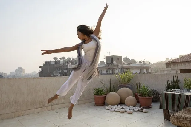 Egyptian 26-year-old dancer Nadine El Gharib, dances on the rooftop of her home in Cairo, Egypt, Monday, September 27, 2021. “Dance was crucial when COVID-19 started in terms of taking care of my well-being”, Gharib said. “When restrictions forced us to stop going to the Opera for classes I started online dance and it introduced me to a new world of dance. It was very inspiring”. (Photo by Nariman El-Mofty/AP Photo)