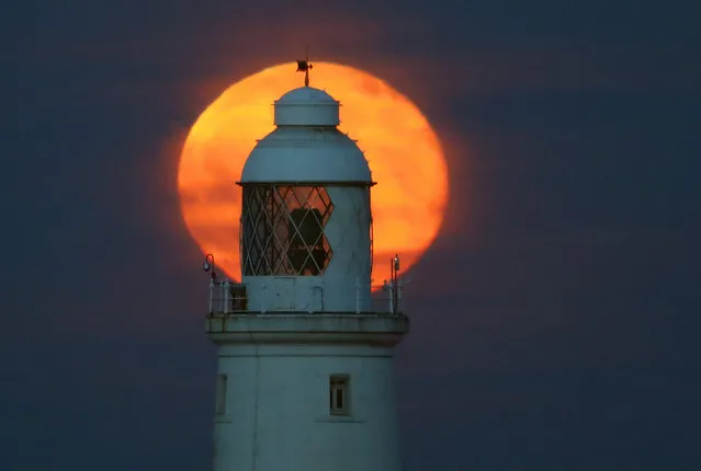 Thursday night’s full moon, known as the flower moon, rises behind St Mary’s Lighthouse, Whitley Bay, UK on May 11, 2017. (Photo by Owen Humphreys/PA Wire)