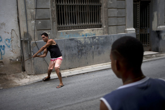 Young baseball players practice their skills with sticks and bottle caps in Old Havana, Cuba, Saturday, March 19, 2016. (Photo by Rebecca Blackwell/AP Photo)
