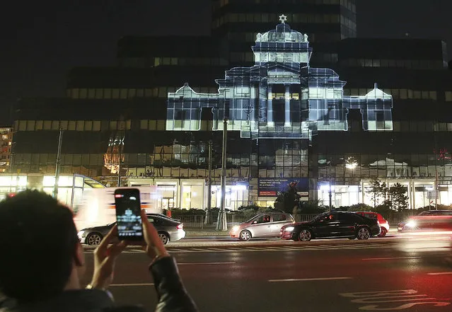 The Great Synagogue of Warsaw, which was destroyed by the German forces during World War II, was recreated virtually with light as part of anniversary commemorations of the 1943 uprising in the Warsaw Ghetto, in Warsaw, Poland, Thursday, April 18, 2019. The multimedia installation, which included the archival recordings of a prewar cantor killed in the Holocaust, is the work of Polish artist Gabi von Seltmann. It was organized by a group that fights anti-Semitism. (Photo by Czarek Sokolowski/AP Photo)