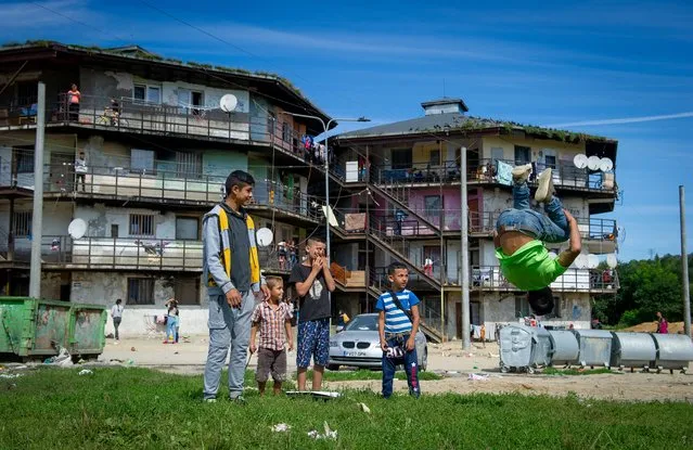 Children play outside houses of the Roma settlement at the Lunik IX quarter of Slovakia's second largest city of Kosice, Sunday, September 5, 2021. (Photo by Peter Lazar/AP Photo)