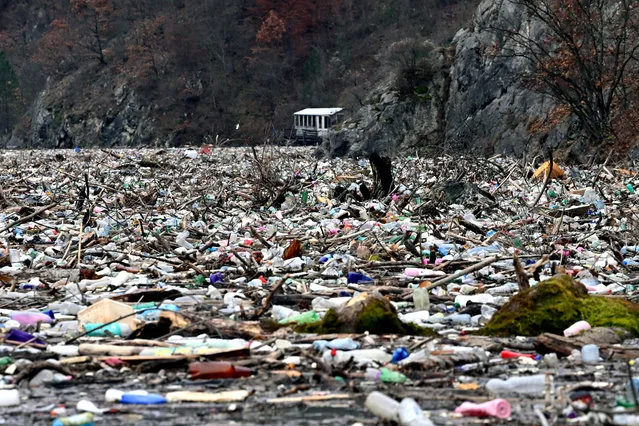 This photograph taken on January 26, 2023 shows waste and debris floating behind a primitive floating fender on the river Drina, near Visegrad, eastern Bosnia and Herzegovina. The waste and debris were carried into the Drina River from neighbouring municipalities in Bosnia and the neighbouring countries of Serbia and Montenegro after the recent floods. Local authorities fear that the defences will break down under the increased load and give way, causing another ecological disaster and endangering the nearby Visegrad hydroelectric plant. (Photo by Elvis Barukcic/AFP Photo)