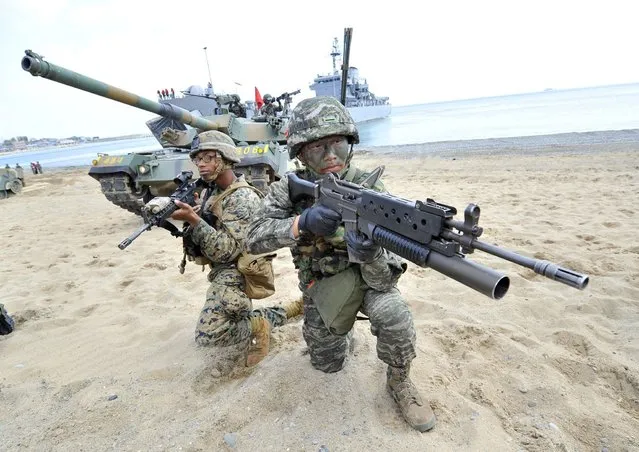 South Korean (R) and US (L) Marines take a position on the seashore during a joint landing operation by US and South Korean Marines in Pohang, 270 kms southeast of Seoul, on April 26, 2013. The US and South Korea staged a military landing exercise as the Korean peninsula was already engulfed in a cycle of escalating tensions triggered by the North Korea's nuclear test in February. (Photo by Jung Yeon-Je/AFP Photo)