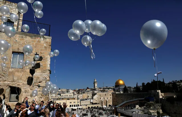 People release balloons as they celebrate a Bar Mitzvah, a traditional Jewish coming of age ceremony, as the Western Wall (right-hand corner) and the Dome of the Rock are seen in the background, in Jerusalem's Old City February 20, 2017. (Photo by Ronen Zvulun/Reuters)
