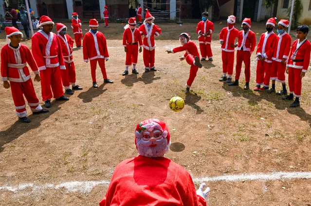 Children dressed as Santa Clause play with a soccer ball as they celebrate at their school ahead of Christmas in Chennai on December 23, 2021. (Photo by Arun Sankar/AFP Photo)