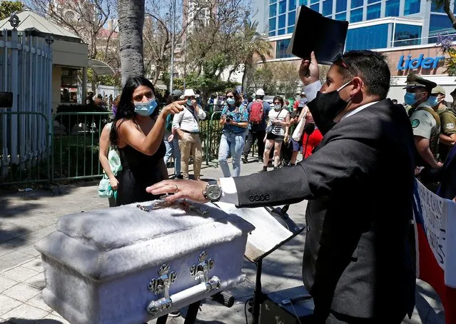 A preacher holds a bible next to an empty child's coffin as a pro-choice activist reacts, outside Congress where lawmakers will begin to discuss a bill that decriminalises abortion until the 14th week of gestation, in Valparaiso, Chile on January 13, 2021. (Photo by Rodrigo Garrido/Reuters)