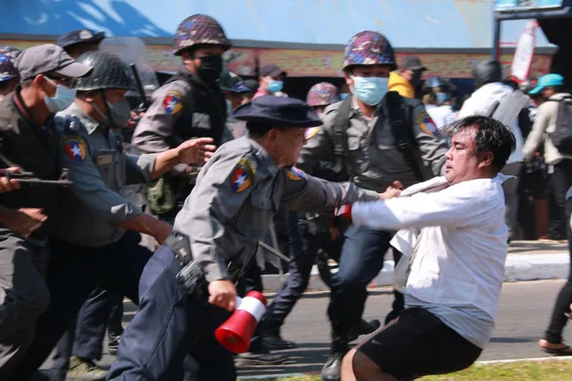 Police arrest a protester during a demonstration against the military coup in Mawlamyine in Mon State on February 12, 2021. (Photo by AFP Photo/Stringer)