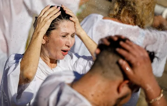 Worshippers take part in a baptism ceremony at the Jordan River to celebrate Epiphany, in what is believed to be the site of Jesus' baptism, near Jericho in the Israeli-occupied West Bank on January 18, 2022. (Photo by Raneen Sawafta/Reuters)
