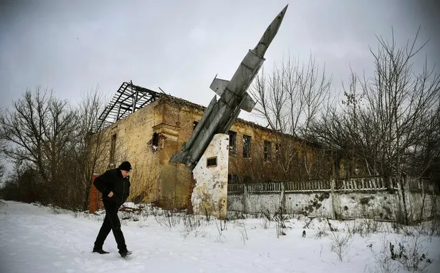 A man walks past a destroyed building of a former military installation in the village of Vesyoloye, suburb of Donetsk, capital of a self-proclaimed Donetsk People's Republic (PDR) in eastern Ukraine, on January 18, 2022. (Photo by Alexander Nemenov/AFP Photo)