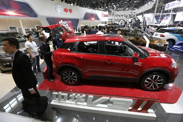 Visitors look at the Chinese automaker China Motor V3II SUV on display at the Beijing International Automotive Exhibition in Beijing, Monday, April 25, 2016. (Photo by Andy Wong/AP Photo)