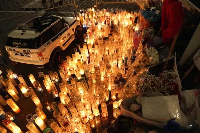 Candles blaze from a makeshift memorial outside the 32nd police precinct in Harlem, New York on January 24, 2022, after the shooting of two police officers, Jason Rivera and Wilbert Mora. (Photo by Catherine Nance/SOPA Images/Rex Features/Shutterstock)