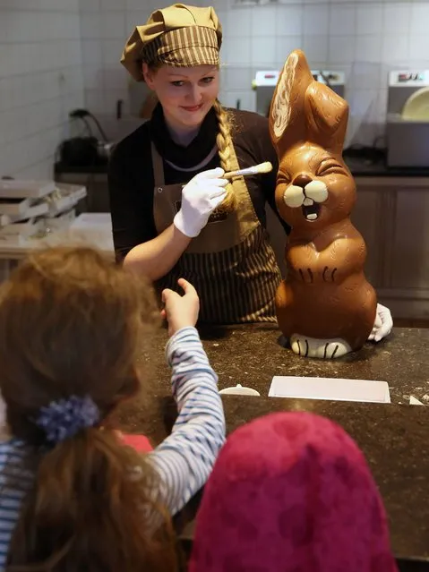 Sandra Jaeckel demonstrates a brush technique on a giant chocolate Easter bunny at Confiserie Felicitas chocolates maker in Hornow. (Photo by Sean Gallup/Getty Images)