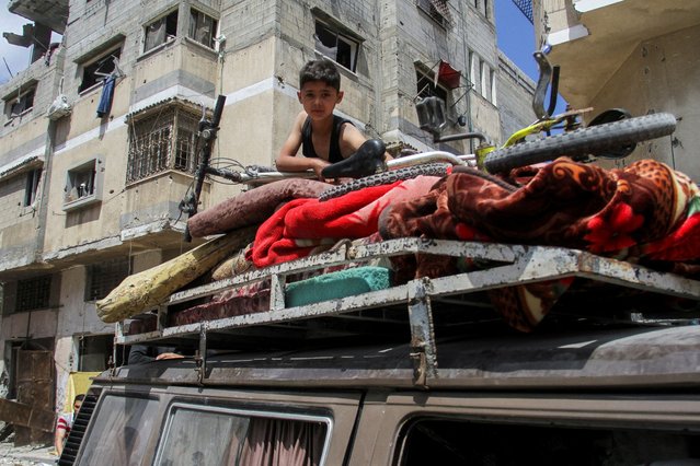 A Palestinian boy sits atop a vehicle loaded with belongings as he returns to his house at Zeitoun neighborhood after Israeli forces withdrew from the area following a raid, in Gaza City, on May 15, 2024. (Photo by Mahmoud Issa/Reuters)