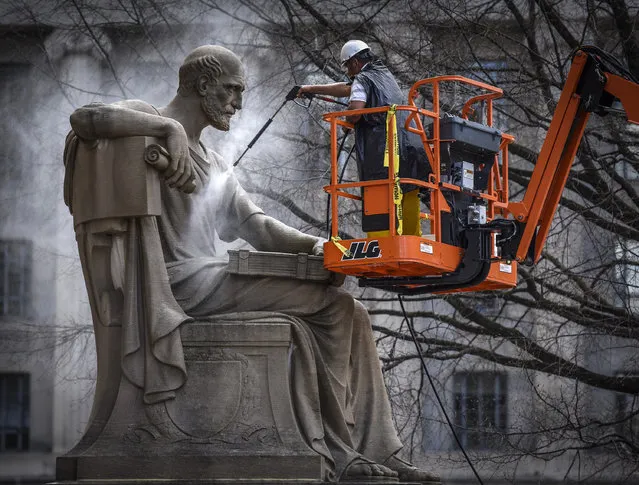 Contractors give a spring cleaning to Robert Aitken's statue “Study the Past”, located on the Pennsylvania avenue side of the National Archives, on April, 04, 2017 in Washington, DC. (Photo by Bill O'Leary/The Washington Post)