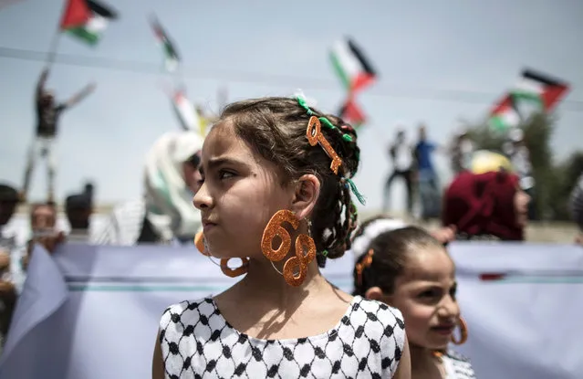 Palestinian girls wear earrings bearing the number “68” and hair slides in the shape of a key on May 15, 2016 in Gaza city during a rally to commemorate the “Nakba” in reference to the establishment in 1948 of the state of Israel. “Nakba” means in Arabic “catastrophe” in reference to the birth of the state of Israel 68-years-ago in British-mandate Palestine, which led to the displacement of hundreds of thousands of Palestinians who either fled or were driven out of their homes during the 1948 war over Israel's creation. (Photo by Mahmud Hams/AFP Photo)