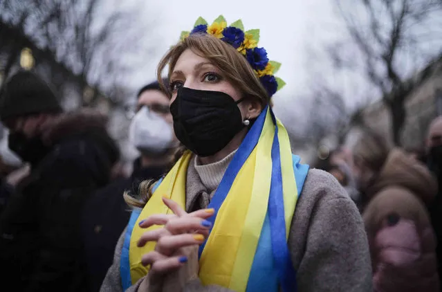 A woman wears Ukrainian national colors at a demonstration along the street near the Russian embassy to protest against the escalation of the tension between Russia and Ukraine in Berlin, Germany, Tuesday, February 22, 2022. Lawmakers gave Russian President Vladimir Putin permission to use military force outside the country on Tuesday. The move that could presage a broader attack on Ukraine after the U.S. said an invasion was already underway there. (Photo by Markus Schreiber/AP Photo)