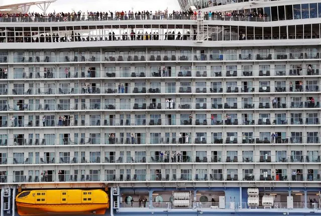 Passengers wave from the decks as the Harmony of the Seas cruise ship sets sail from Southampton, southern England, on May 22, 2016. At 120,000 tons and 217 feet, Royal Caribbean's “Harmony of the Seas” is the biggest cruise ship ever built. (Photo by Adrian Dennis/AFP Photo)