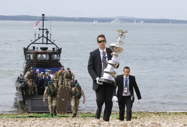 The America's Cup Trophy is carried from a Royal Marine landing craft after it arrived at the waterfront festival area in Portsmouth, England, Thursday, July 23, 2015. The event in Portsmouth is one of the America's Cup World Series qualifying events, ahead of the 35th Americas Cup in 2017. Racing takes place on July 25 and 26. (Photo by Kirsty Wigglesworth/AP Photo)