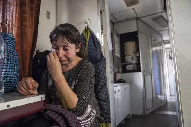 A woman from Luhansk region cries while sitting on the evacuation train in Pokrovsk, eastern Ukraine, Tuesday, April 26, 2022. (Photo by Evgeniy Maloletka/AP Photo)
