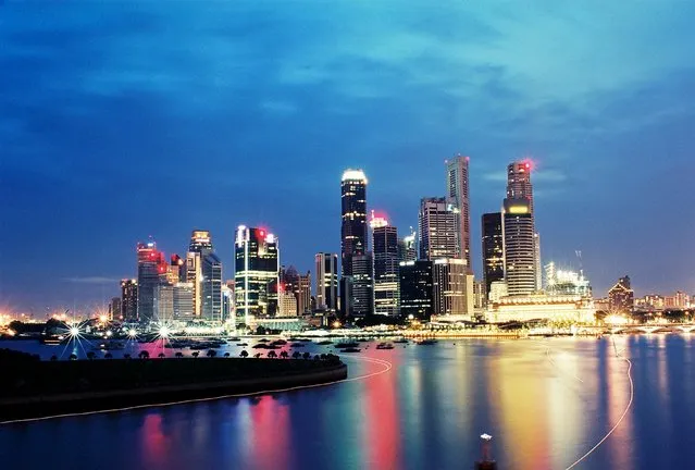 Small transportation boats, known as bumboats, leave trails of light as they travel across Marina Bay past the skyline of Singapore in this photo taken in 2004. Singapore holds a Jubilee weekend from 7 to 10 August to celebrate the 50th anniversary of its independence. (Photo by Edgar Su/Reuters)