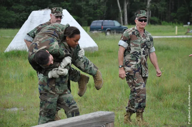 Construction Electrician Constructionman Whitney Shields, assigned to Naval Mobile Construction Battalion (NMCB) 23, carries Builder Constructionman Antonio Mudge on her shoulders during a confidence course training as part of the sixth annual Seabee Rodeo at Naval Air Station Jacksonville