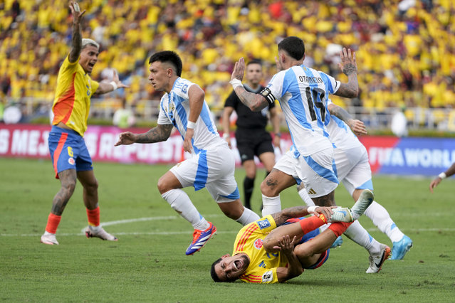 Colombia's Daniel Munoz, below, grimaces in pain after being fouled by Argentina's Nicolas Otamendi during a qualifying soccer match for the FIFA World Cup 2026 at the Metropolitano Roberto Melendez stadium in Barranquilla, Colombia, Tuesday, September 10, 2024. (Photo by Ricardo Mazalan/AP Photo)