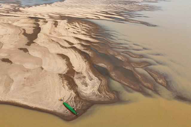 A drone view shows Reis Santo Vieira da Silva as a river dweller builds a canoe on the sandbanks of Madeira River during the worst drought of the river in history, in Humaita, Amazonas state, Brazil, on September 7, 2024. (Photo by Bruno Kelly/Reuters)