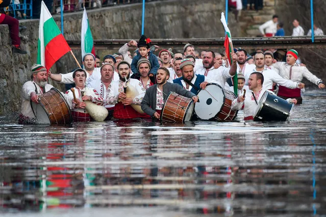 Bulgarian men perform the traditional “Horo” dance in the icy winter waters of the Tundzha river in the town of Kalofer, as part of Epiphany Day celebrations on January 6, 2020. As a tradition, an Eastern Orthodox priest throws a cross in the river and it is believed that the one who retreives it will be healthy throughout the year as well as all those who dance in the icy waters. (Photo by Nikolay Doychinov/AFP Photo)