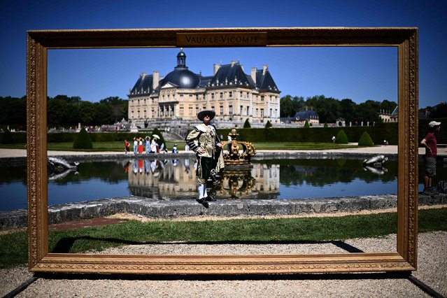 A man dressed in a 17th-century costume poses as he takes part in “La grande journee des costumés”, an historical event gathering hundreds at the Vaux-le-Vicomte castle (background) in Maincy, some 50 kms south-east of Paris on June 25, 2023. (Photo by Christophe Archambault/AFP Photo)